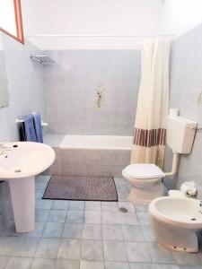 La salle de bains est pourvue d'un lavabo, de toilettes et d'une baignoire. dans l'établissement Vista Mar 2, à Albufeira