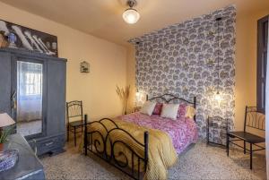 1 dormitorio con cama y pared en Casa La nana de Lorca a 15 min de Granada, en Fuente Vaqueros