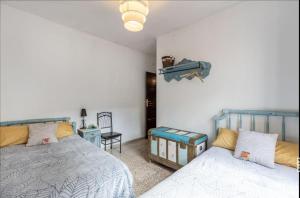 1 dormitorio con 2 camas y una cámara en la pared en Casa La nana de Lorca a 15 min de Granada en Fuente Vaqueros