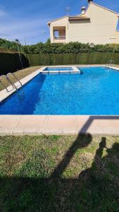 een groot blauw zwembad voor een huis bij Oliva Moon in Oliva