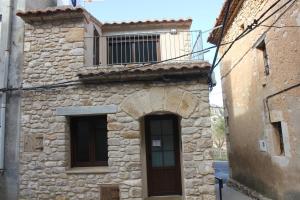 un antiguo edificio de piedra con una ventana y una puerta en CASA RURAL MENSIN, en Villar de Canes