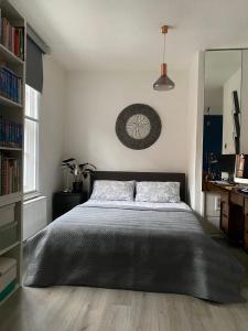 a bedroom with a large bed with a black blanket at Centrally Located London Apartment in London