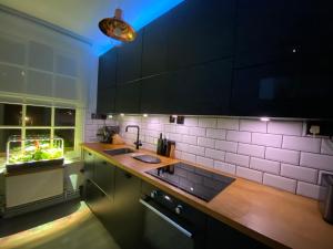 a kitchen with a sink and a counter with purple lights at Centrally Located London Apartment in London