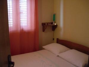 a small bedroom with a bed and a window at Apartment Marina in Sevid