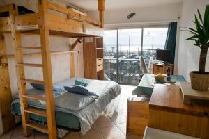 una camera con letto a castello, scrivania e finestra di Le Concorde*Vue Mer*Clim* a La Grande-Motte