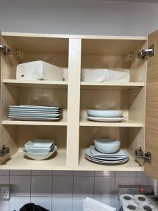 a kitchen with plates and dishes on shelves at Greenwich Luxury View Apartment in London