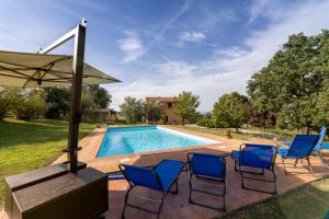 piscina con sedie e ombrellone di Villa Collemancio la soleggiata a Bevagna