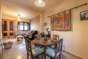 a living room with a table and chairs at Casa La nana de Lorca a 15 min de Granada in Fuente Vaqueros