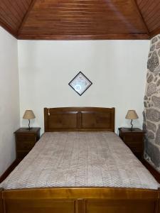 a bedroom with a bed with two nightstands and two lamps at Casa Padre Alexandre in Covide