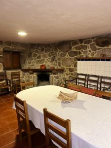 a room with a table and chairs and a stone wall at Casa Padre Alexandre in Covide