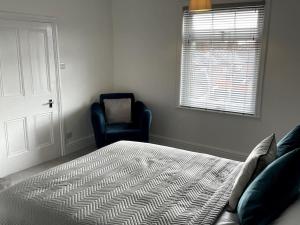 a bedroom with a bed and a chair and a window at Priestley Apartments Ap 2 in Nantwich