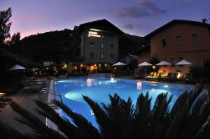 a large swimming pool at a hotel at night at Hotel Florida in Levico Terme