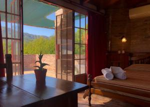 sypialnia ze stołem, oknem i łóżkiem w obiekcie Hostal Las Golondrinas w mieście Bialet Massé