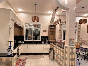 uma cozinha com armários brancos e uma mesa e cadeiras em Villa Koebi em Monte ʼArrouit