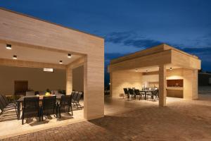 een patio met tafels en stoelen en een open haard bij Malibu Imperial Resort in Vir