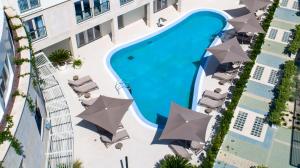 烏馬格的住宿－Royal Blue Suite，享有带遮阳伞的大楼游泳池的顶部景致