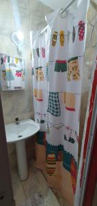 a bathroom with a shower curtain and a sink at Casa Caiçara Centro in Paraty