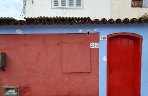 a red and blue building with a red door at Casa Caiçara Centro in Paraty