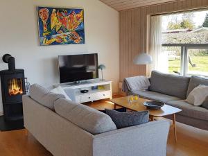 a living room with a couch and a tv and a fireplace at Two-Bedroom Holiday home in Stubbekøbing 2 in Stubbekøbing