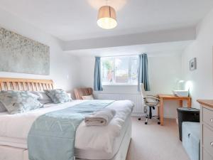 a bedroom with a bed and a desk and a window at Turnstone House in Birchington