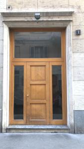 - une porte en bois dans un bâtiment avec une fenêtre dans l'établissement Corso Genova - Milano Navigli, à Milan