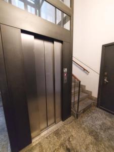 Une porte d'ascenseur est installée dans un immeuble avec des escaliers. dans l'établissement Corso Genova - Milano Navigli, à Milan