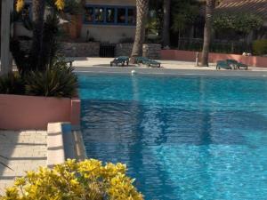 uma piscina com água azul num resort em COQUET STUDIO WIFI gratuit em Canet-en-Roussillon