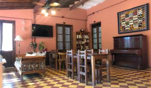 a living room with a piano and a table and chairs at Hostal Las Golondrinas in Bialet Massé