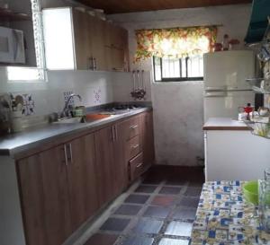 a kitchen with a sink and a refrigerator at Acogedora casa de campo en el oriente de Antioquia in El Retiro