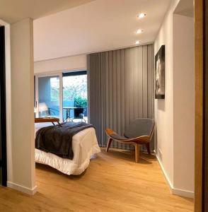 a bedroom with a bed and a chair and a window at Apartamento deluxe en Pocitos_Life Veintiseis Apartments in Montevideo