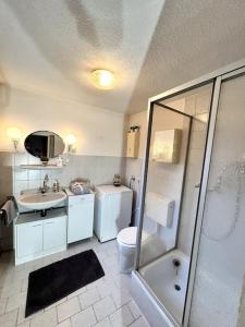uma casa de banho com um chuveiro, um lavatório e um WC. em ART House /15 Min. Düsseldorf Messe,Airport & City em Meerbusch