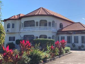 Casa blanca grande con techo de baldosa en PearlieRon Place, en Runaway Bay