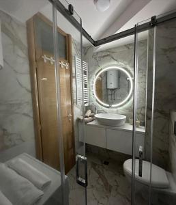 La salle de bains est pourvue d'un lavabo, de toilettes et d'un miroir. dans l'établissement Gondola Apartments, à Jahorina
