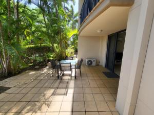 a patio with chairs and a table on a house at BEST Ground Floor pool side Superior apartment - new listing in Gold Coast