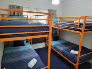 a room with three bunk beds in a dorm room at BEST Ground Floor pool side Superior apartment - new listing in Gold Coast
