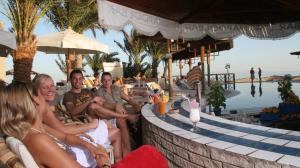 een groep mensen die rond een bar in een resort zitten bij Nesima Resort in Dahab