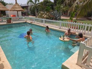 un grupo de personas jugando en una piscina en Chambre d'hôte les vacanciers, en Nianing