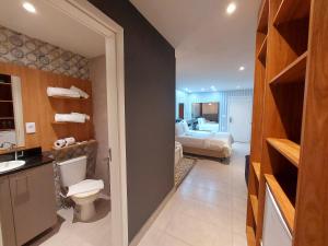 a bathroom with a sink and a toilet and a bedroom at Hotel Vila Suíça 1818 in Nova Friburgo