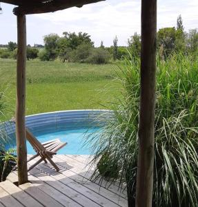 un patio con una silla y una piscina en Hermosa cabaña en la naturaleza. Chacra La Fiaca, en Colonia del Sacramento