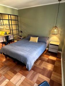 um quarto com uma cama com um edredão azul em Casco Histórico, Lastarria. em Santiago