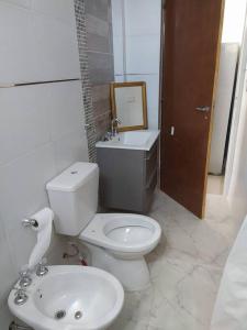 uma casa de banho branca com um WC e um lavatório em Hermoso Apartamento a estrenar em Buenos Aires