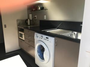 cocina con lavadora y fregadero en Apartment on Stansell, en Nelson