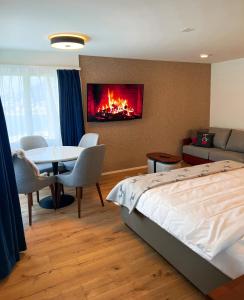 um quarto com uma cama, uma mesa e uma lareira em Wunderstay Alpine 401 Chic Studio with Mountain view em Engelberg