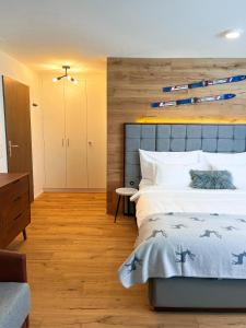 um quarto com uma cama grande e uma parede de madeira em Wunderstay Alpine 401 Chic Studio with Mountain view em Engelberg