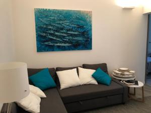 a living room with a brown couch with blue and white pillows at Casa del Limone in Favignana +9 photos