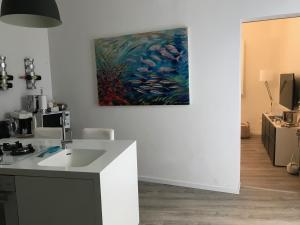 a kitchen with a sink and a painting on the wall at Casa del Limone in Favignana