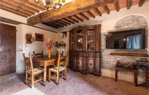 jadalnia z drewnianym stołem i kamienną ścianą w obiekcie 3 Bedroom Cozy Home In Sorana w mieście Aramo