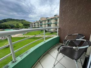 a chair sitting on the balcony of a building at Apartamento/Flat - Condominio Village - Aldeia das Águas Park Resort. in Barra do Piraí
