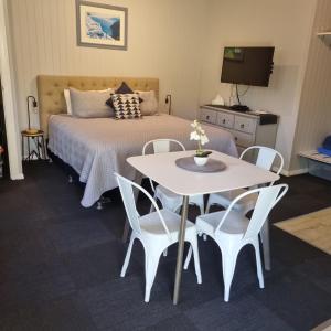 a bedroom with a bed and a table and chairs at Bluegrass BnB in Bundaberg