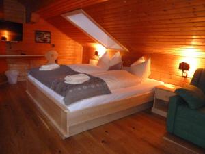 シュラートミンクにあるFerienhaus Almfriedenの木製の部屋に大型ベッドが備わるベッドルーム1室が備わります。